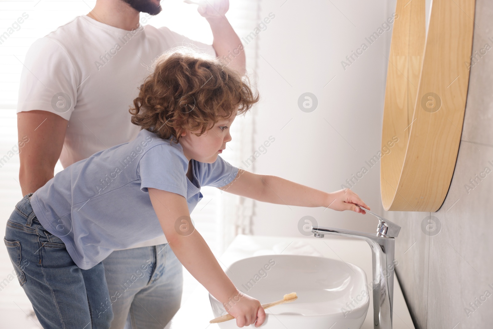 Father and his son with toothbrush in bathroom, closeup Photo of Father and his son with toothbrush in bathroom, closeup
