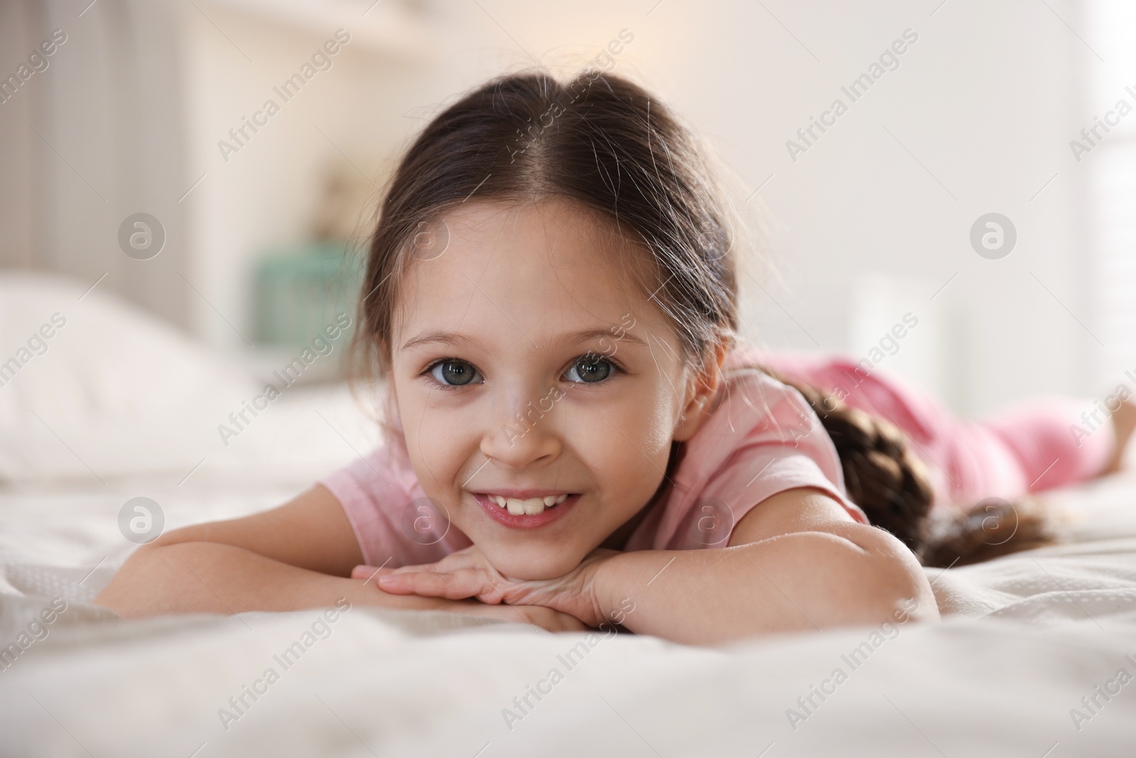 Cute little girl on bed at home Photo of Cute little girl on bed at home
