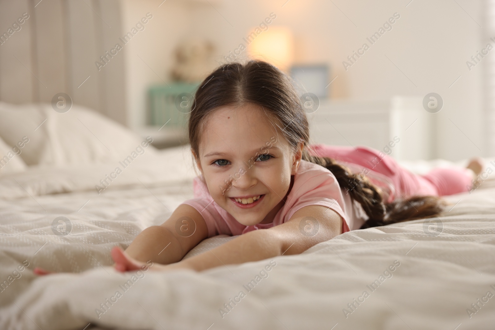 Cute little girl on bed at home Photo of Cute little girl on bed at home