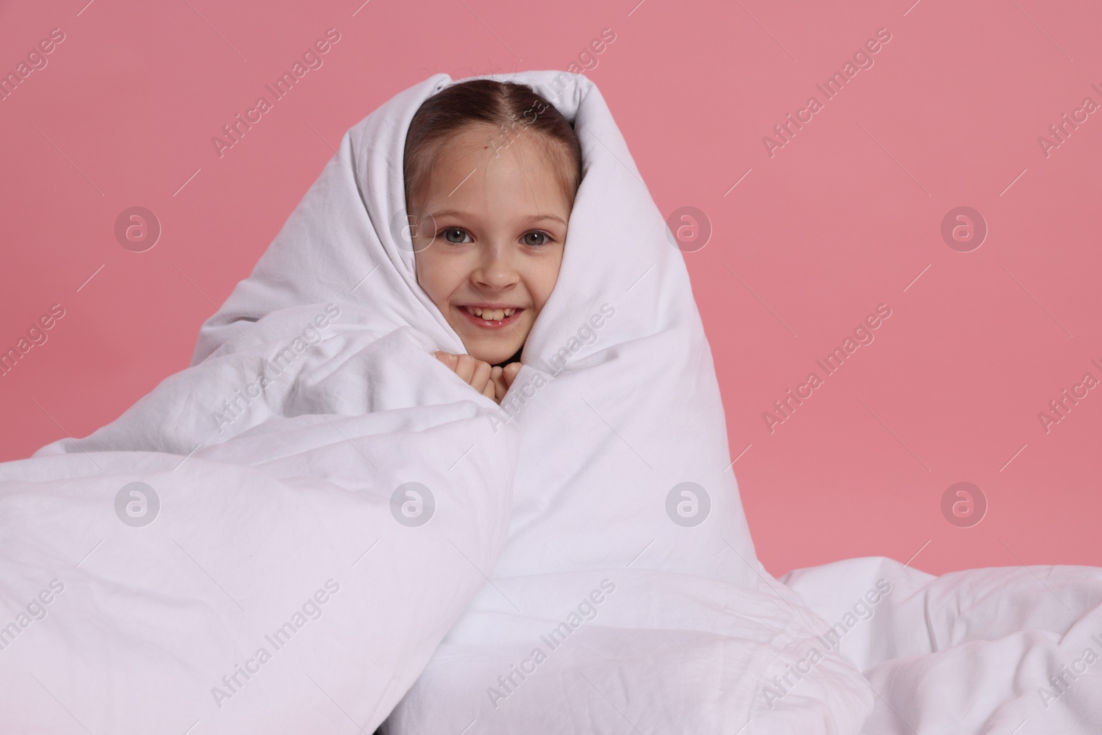 Photo of Cute girl with blanket on pink background