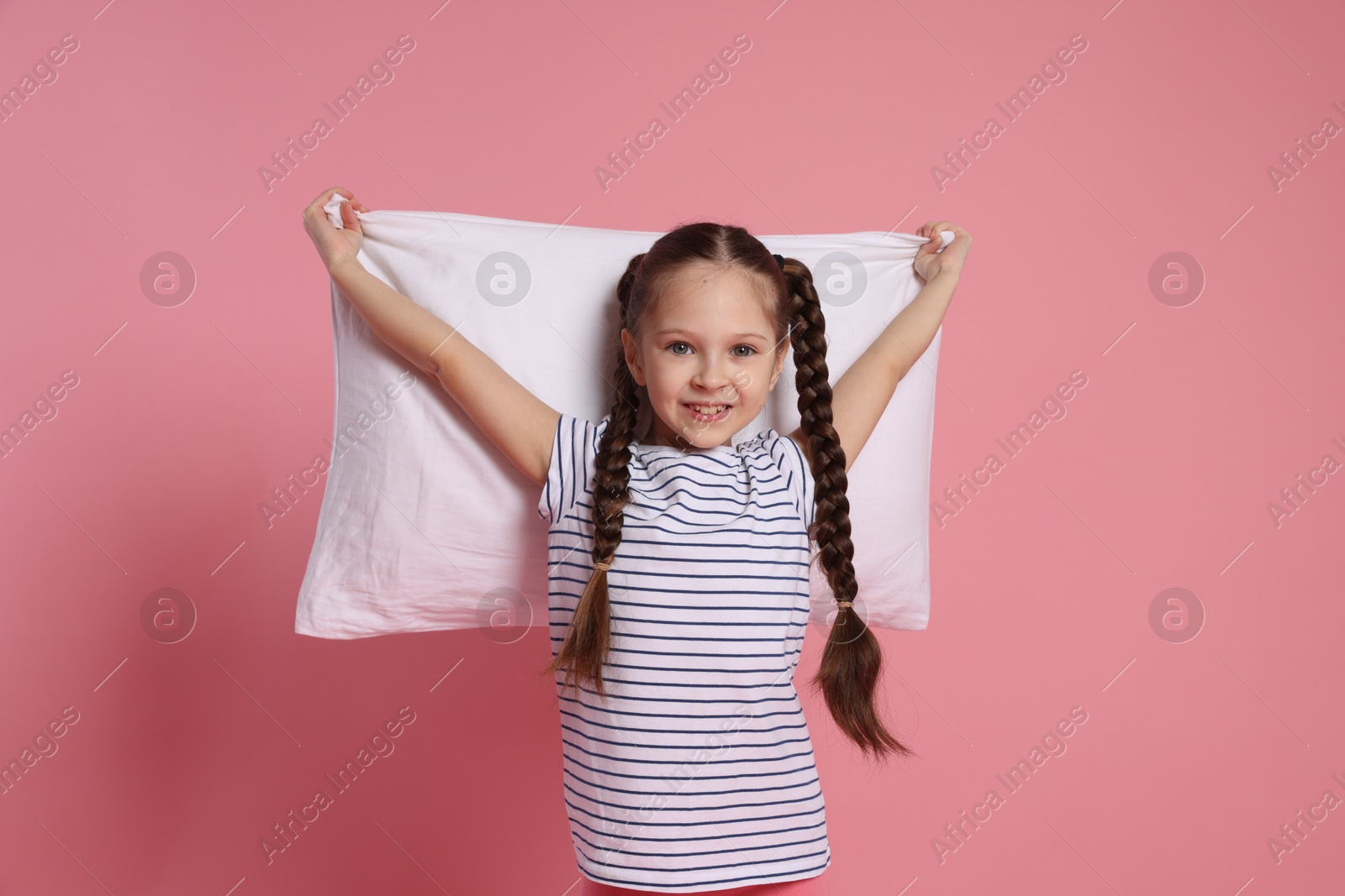 Photo of Cute girl with pillow on pink background