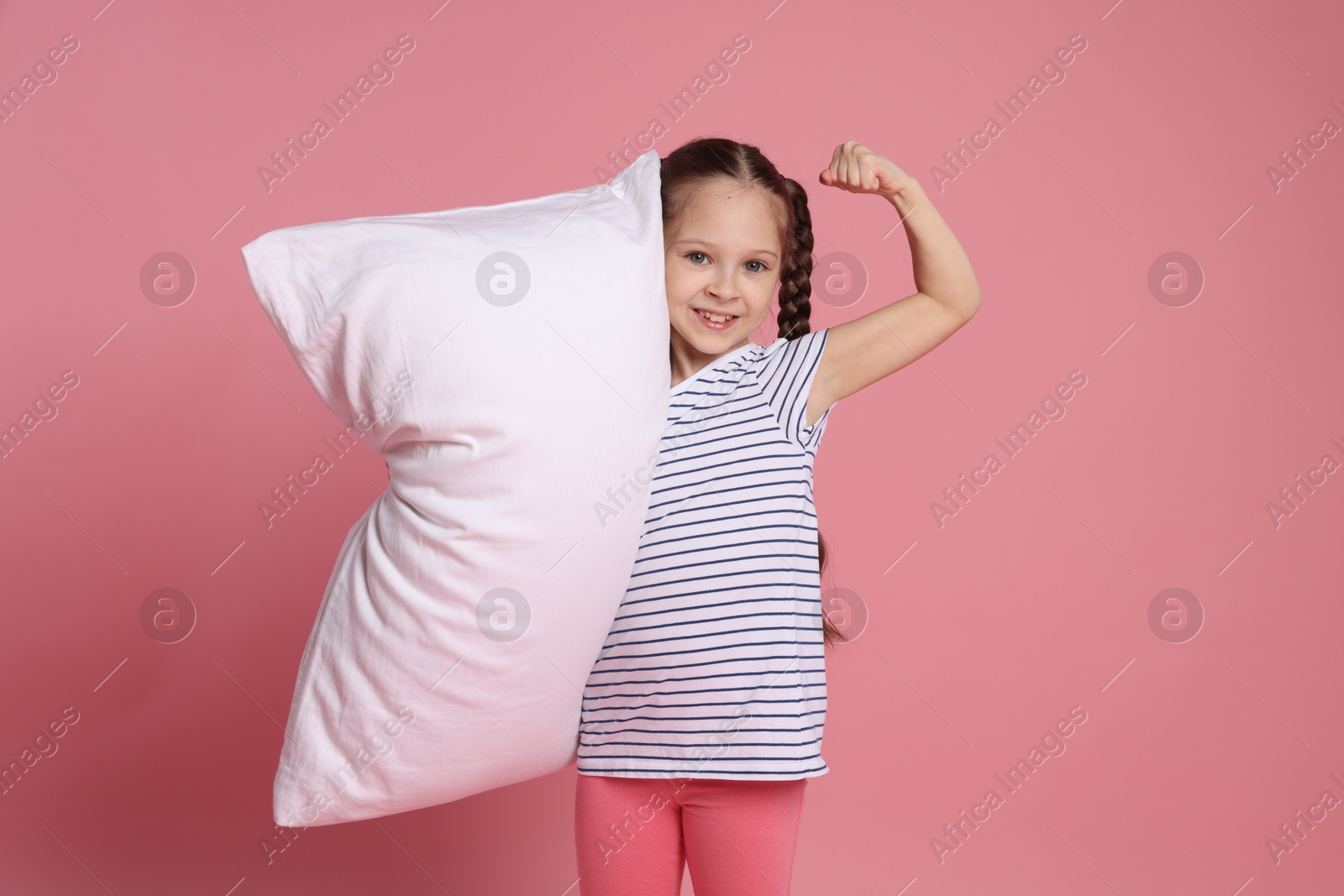 Photo of Cute girl with pillow on pink background