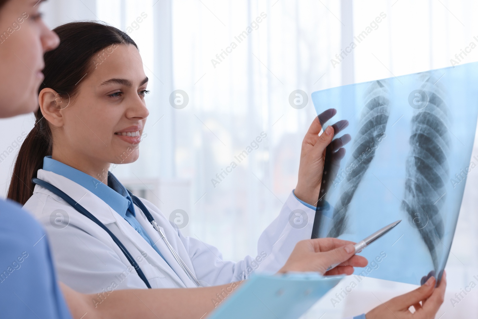 Doctor and nurse examining MRI scan in hospital, closeup Photo of Doctor and nurse examining MRI scan in hospital, closeup