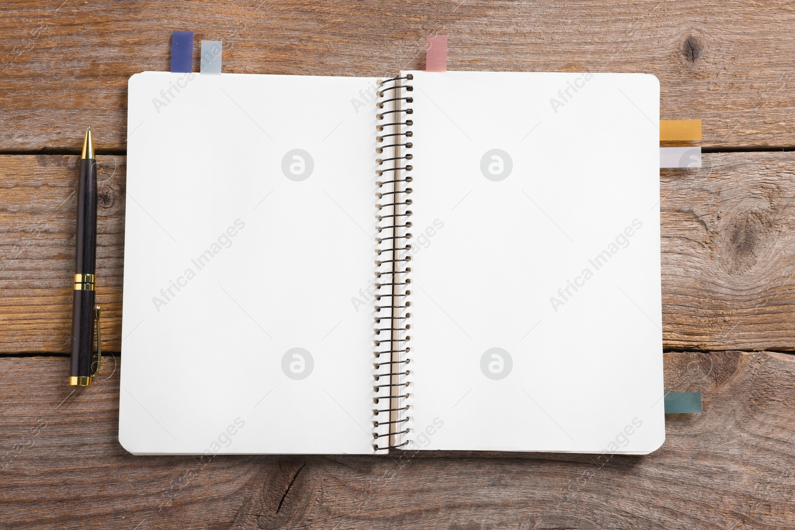 Open blank notebook with bookmarks and pen on wooden table, top view Photo of Open blank notebook with bookmarks and pen on wooden table, top view
