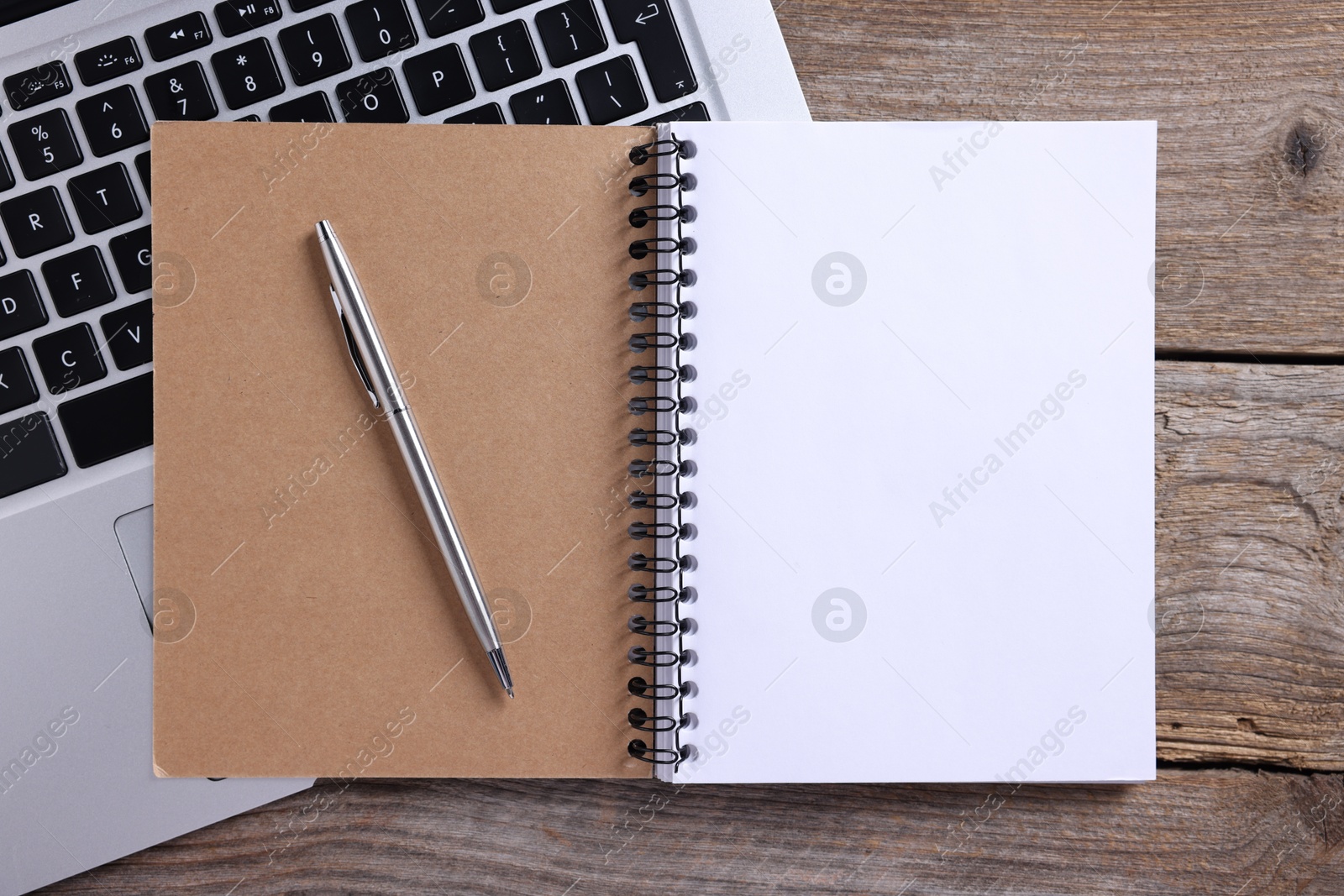 Open blank notebook, laptop and pen on wooden table, flat lay Photo of Open blank notebook, laptop and pen on wooden table, flat lay