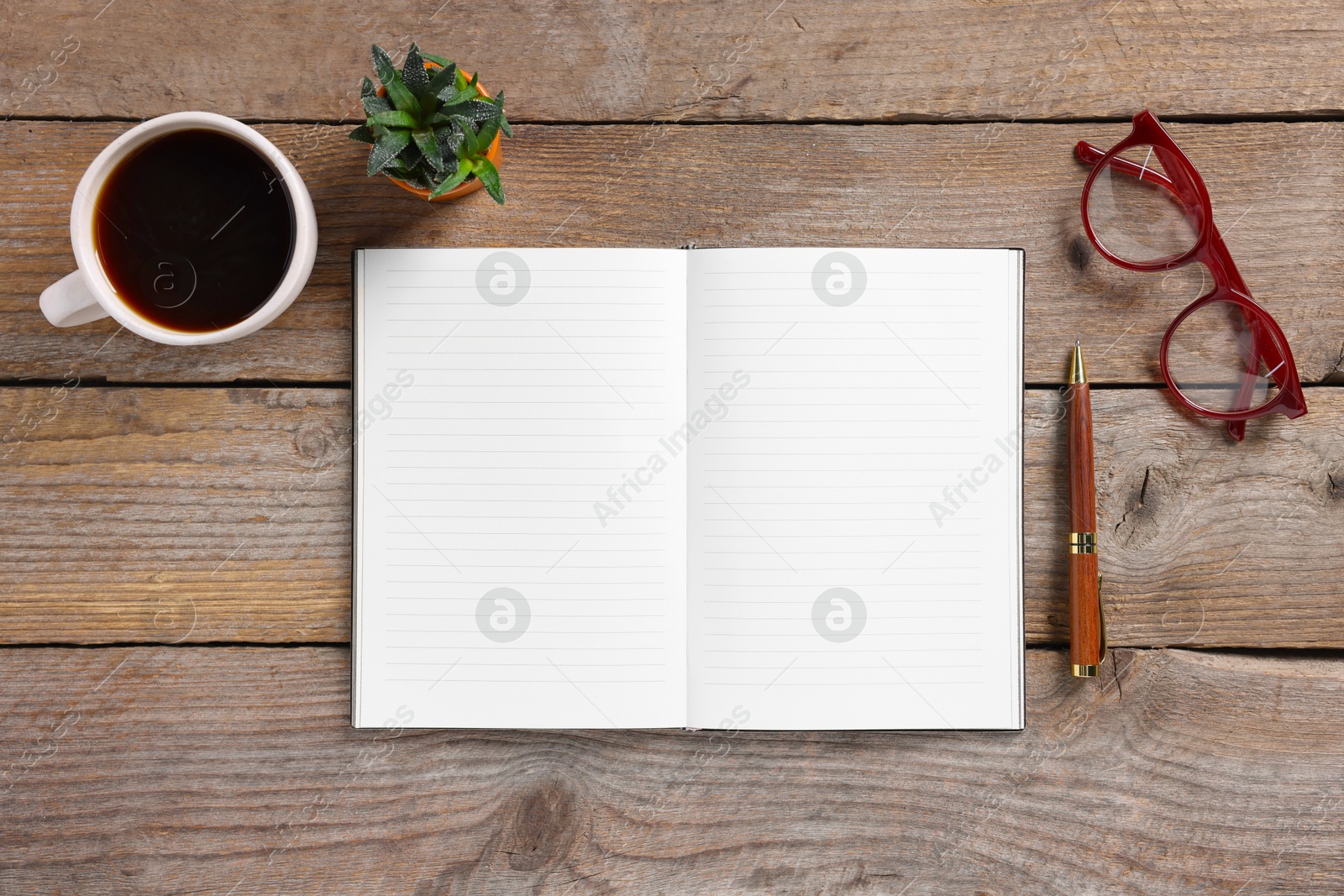 Open blank notebook, coffee, glasses, houseplant and pen on wooden table, flat lay Photo of Open blank notebook, coffee, glasses, houseplant and pen on wooden table, flat lay