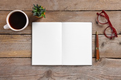 Photo of Open blank notebook, coffee, glasses, houseplant and pen on wooden table, flat lay