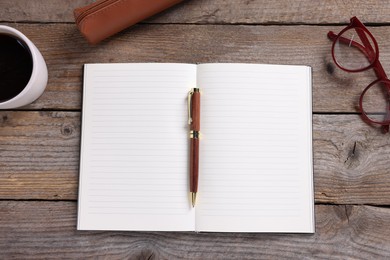 Photo of Open blank notebook, coffee, glasses and pen on wooden table, flat lay