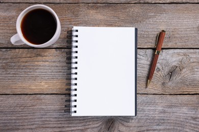 Photo of Open blank notebook, coffee and pen on wooden table, flat lay