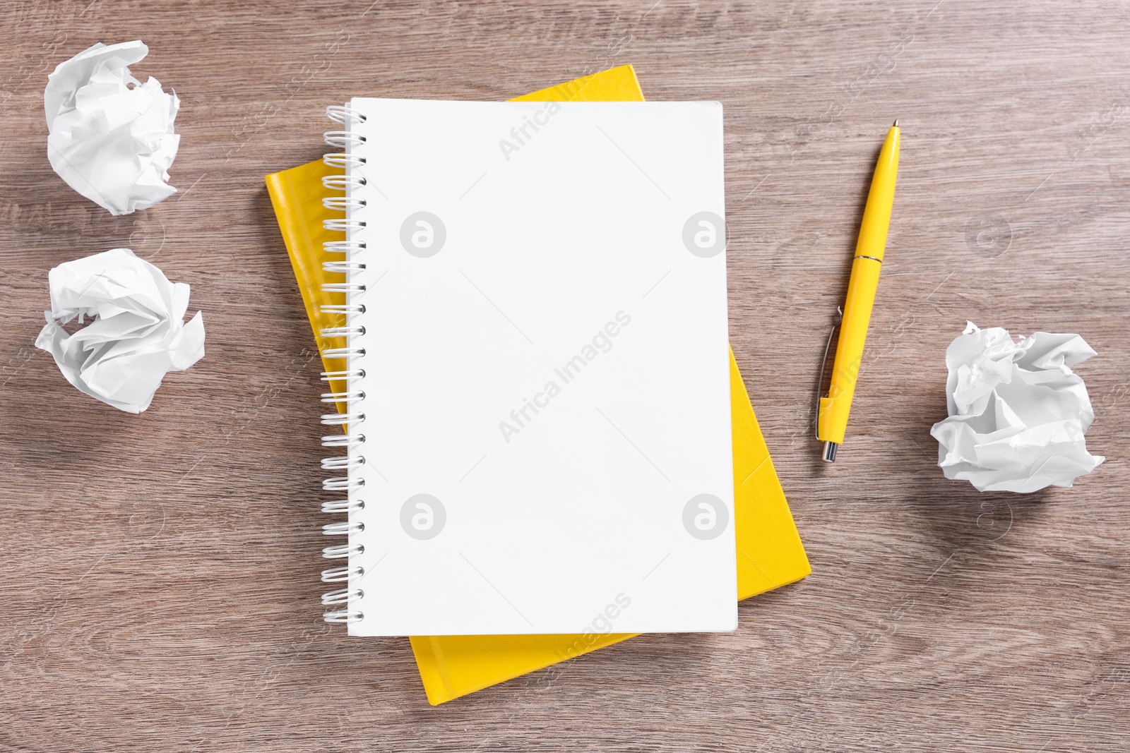 Blank notebooks, crumpled paper and pen on wooden table, flat lay Photo of Blank notebooks, crumpled paper and pen on wooden table, flat lay