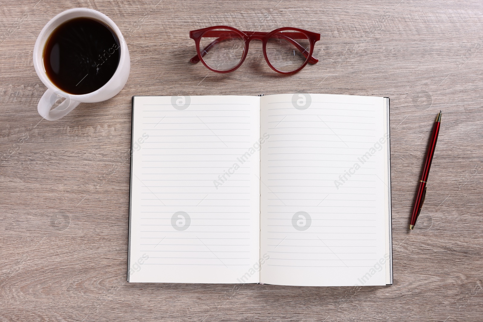Open blank notebook, coffee, pen and glasses on wooden table, flat lay Photo of Open blank notebook, coffee, pen and glasses on wooden table, flat lay