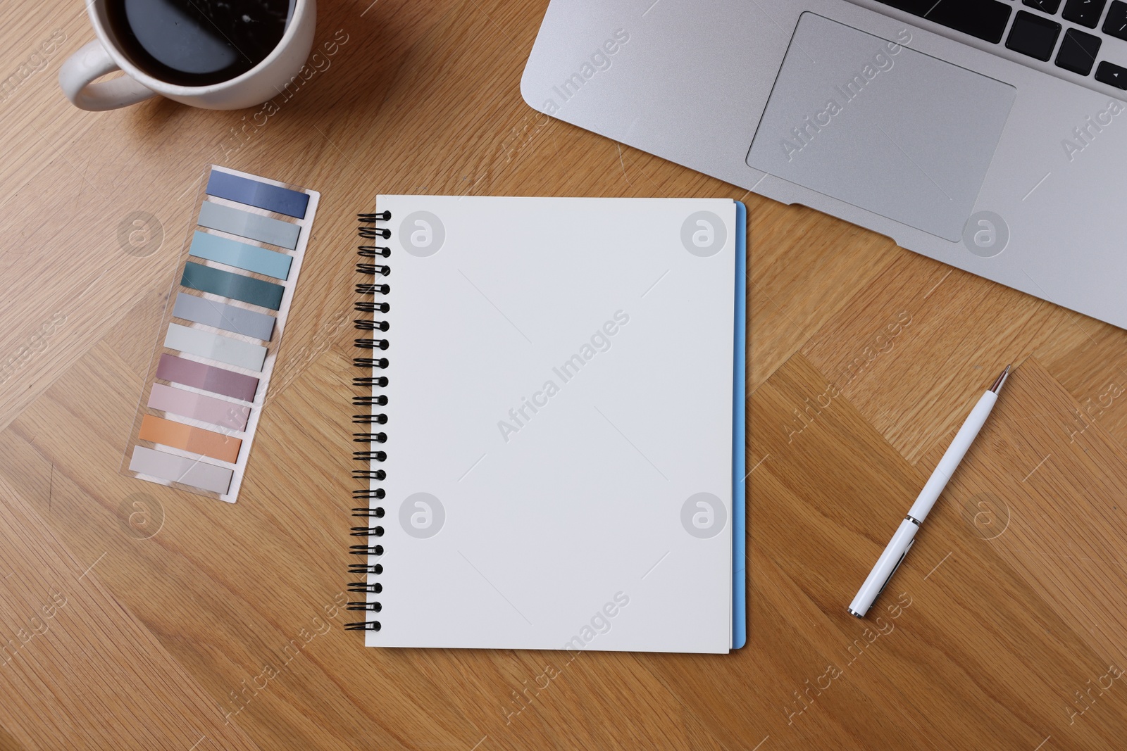 Open blank notebook, coffee, laptop, bookmarks and pen on wooden table, flat lay Photo of Open blank notebook, coffee, laptop, bookmarks and pen on wooden table, flat lay