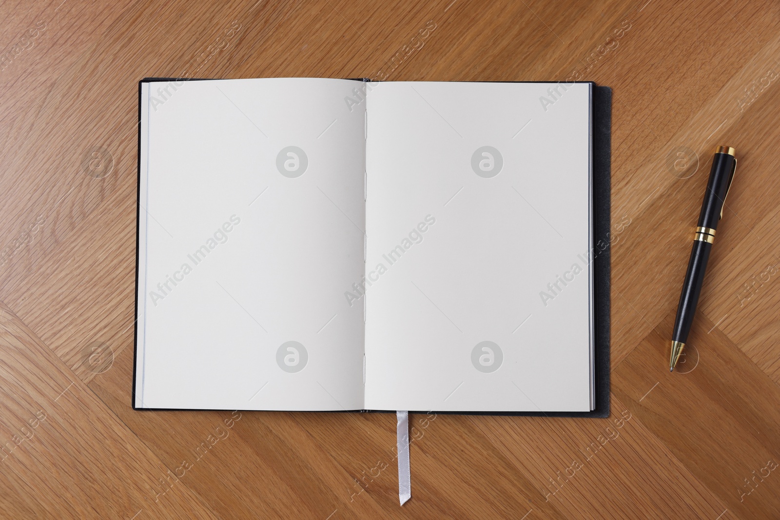 Open blank notebook and pen on wooden table, top view Photo of Open blank notebook and pen on wooden table, top view