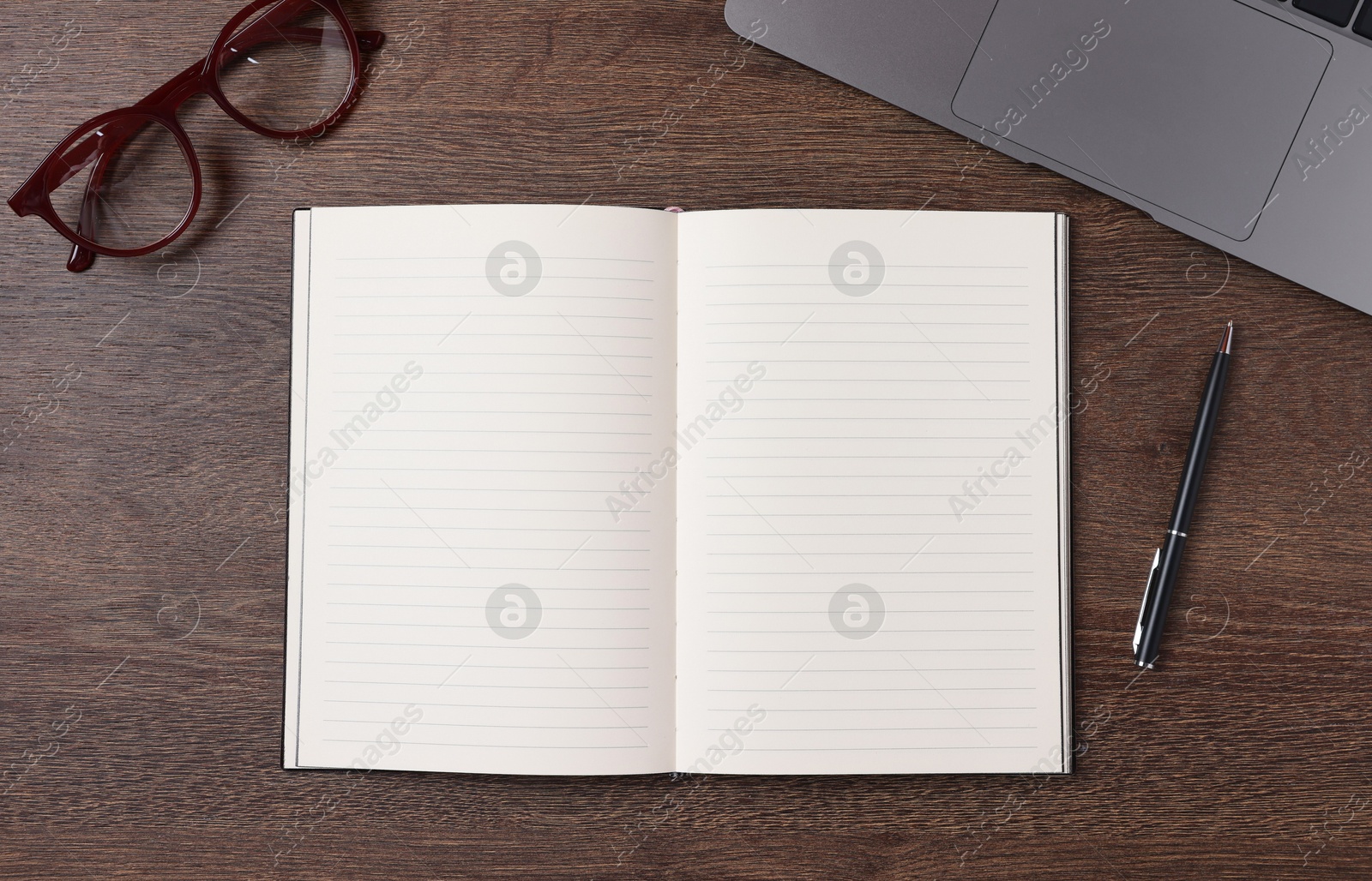 Open blank notebook, laptop, pen and glasses on wooden table, flat lay Photo of Open blank notebook, laptop, pen and glasses on wooden table, flat lay