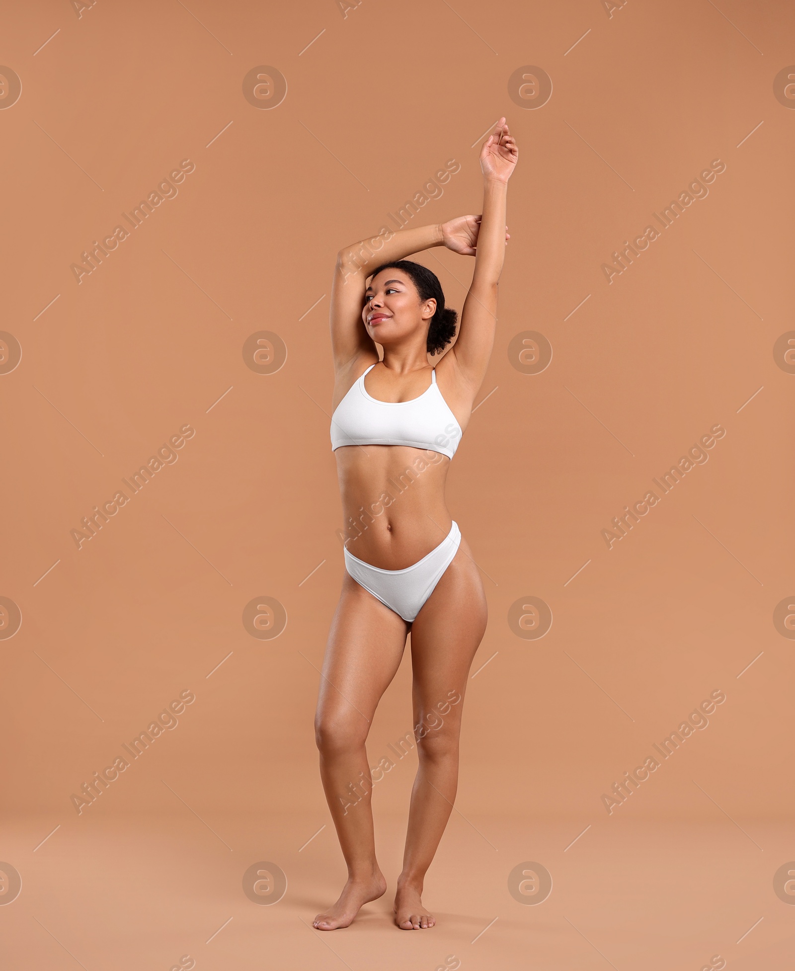 Woman in white underwear with smooth skin after epilation procedure on beige background Photo of Woman in white underwear with smooth skin after epilation procedure on beige background