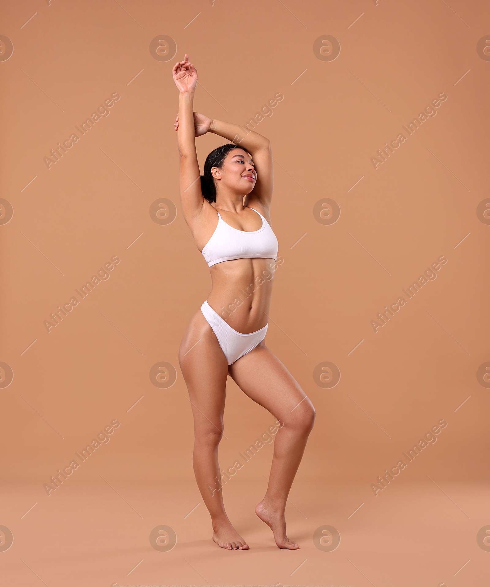 Woman in white underwear with smooth skin after epilation procedure on beige background Photo of Woman in white underwear with smooth skin after epilation procedure on beige background