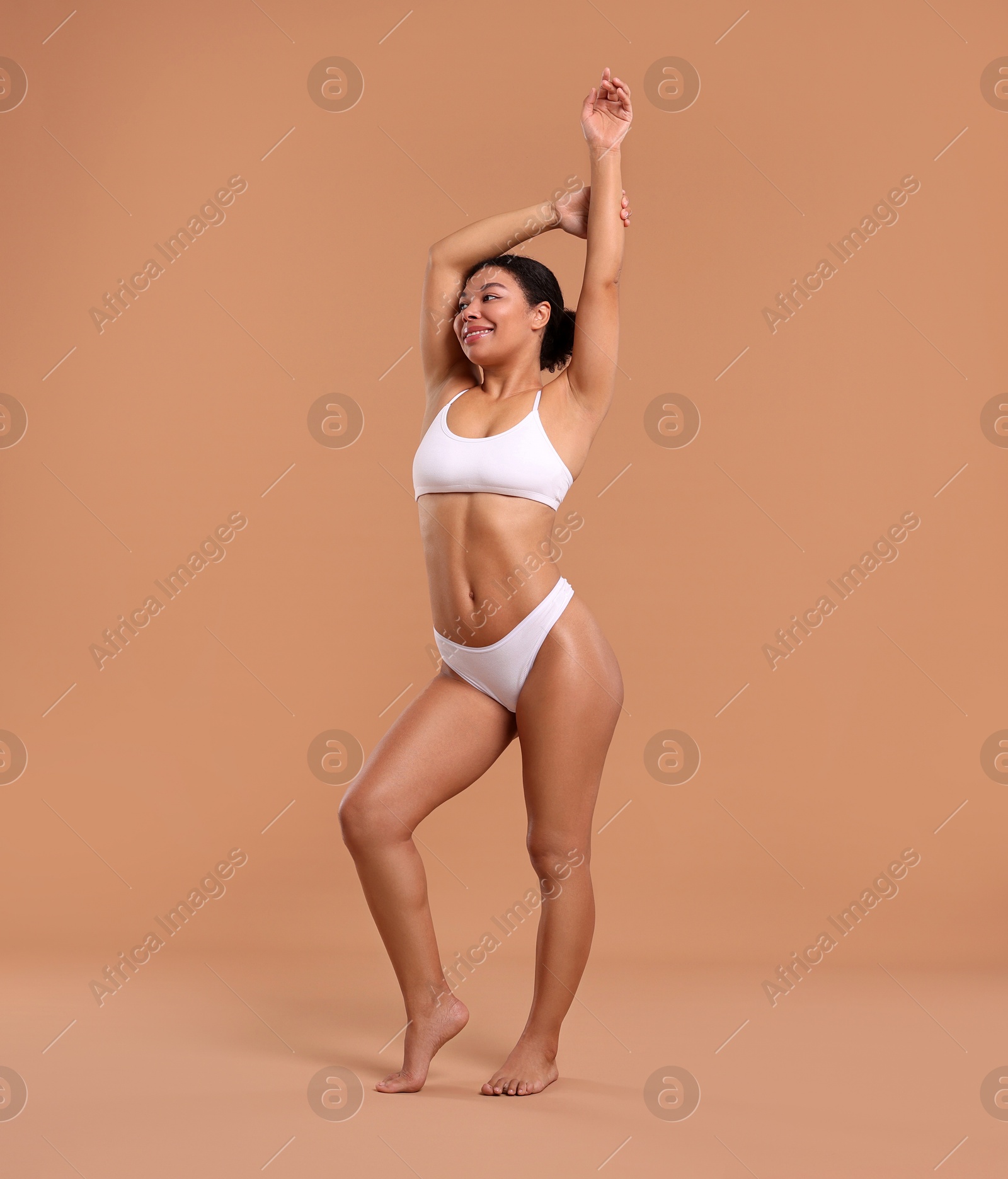 Woman in white underwear with smooth skin after epilation procedure on beige background Photo of Woman in white underwear with smooth skin after epilation procedure on beige background