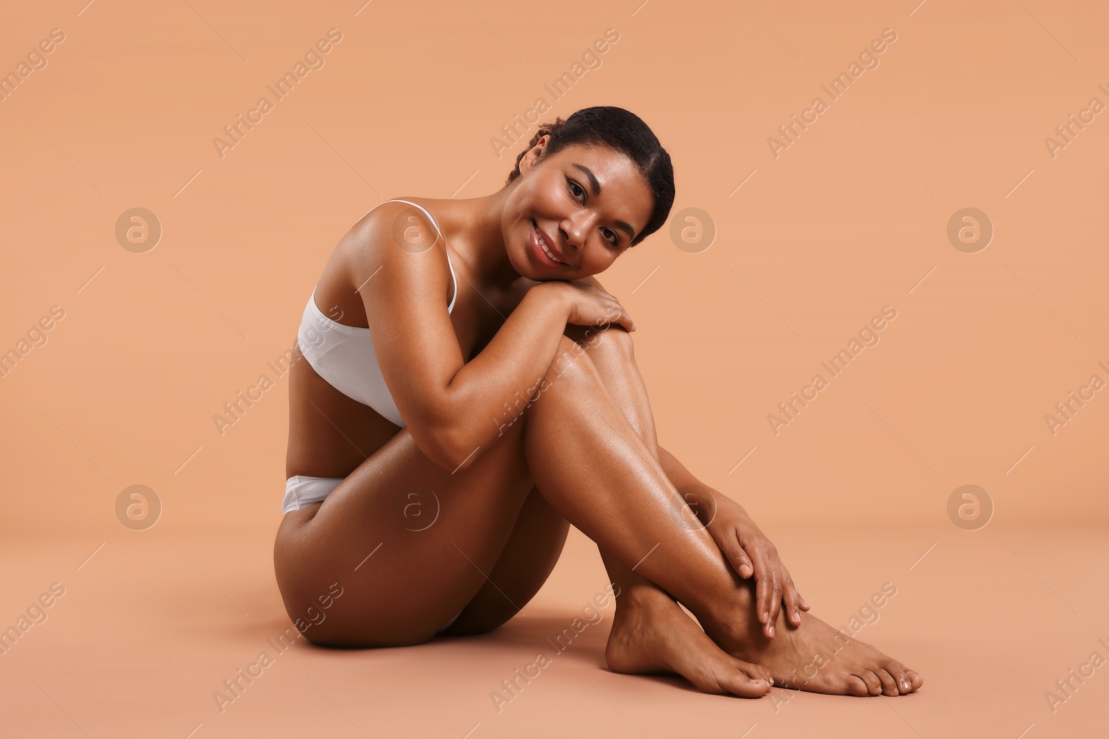 Woman in white underwear with smooth skin after epilation procedure on beige background Photo of Woman in white underwear with smooth skin after epilation procedure on beige background