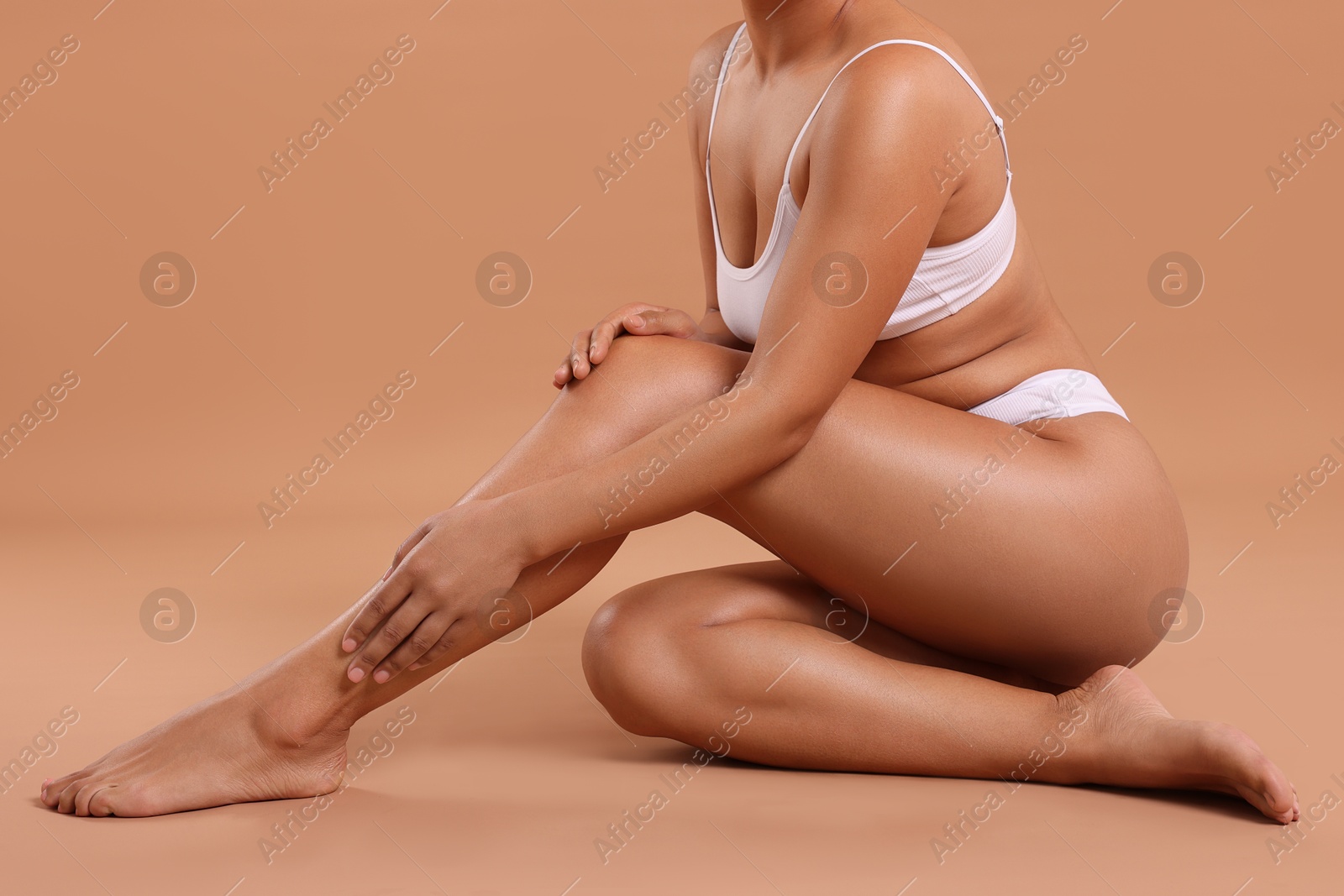 Woman in white underwear with smooth skin after epilation procedure on beige background, closeup Photo of Woman in white underwear with smooth skin after epilation procedure on beige background, closeup