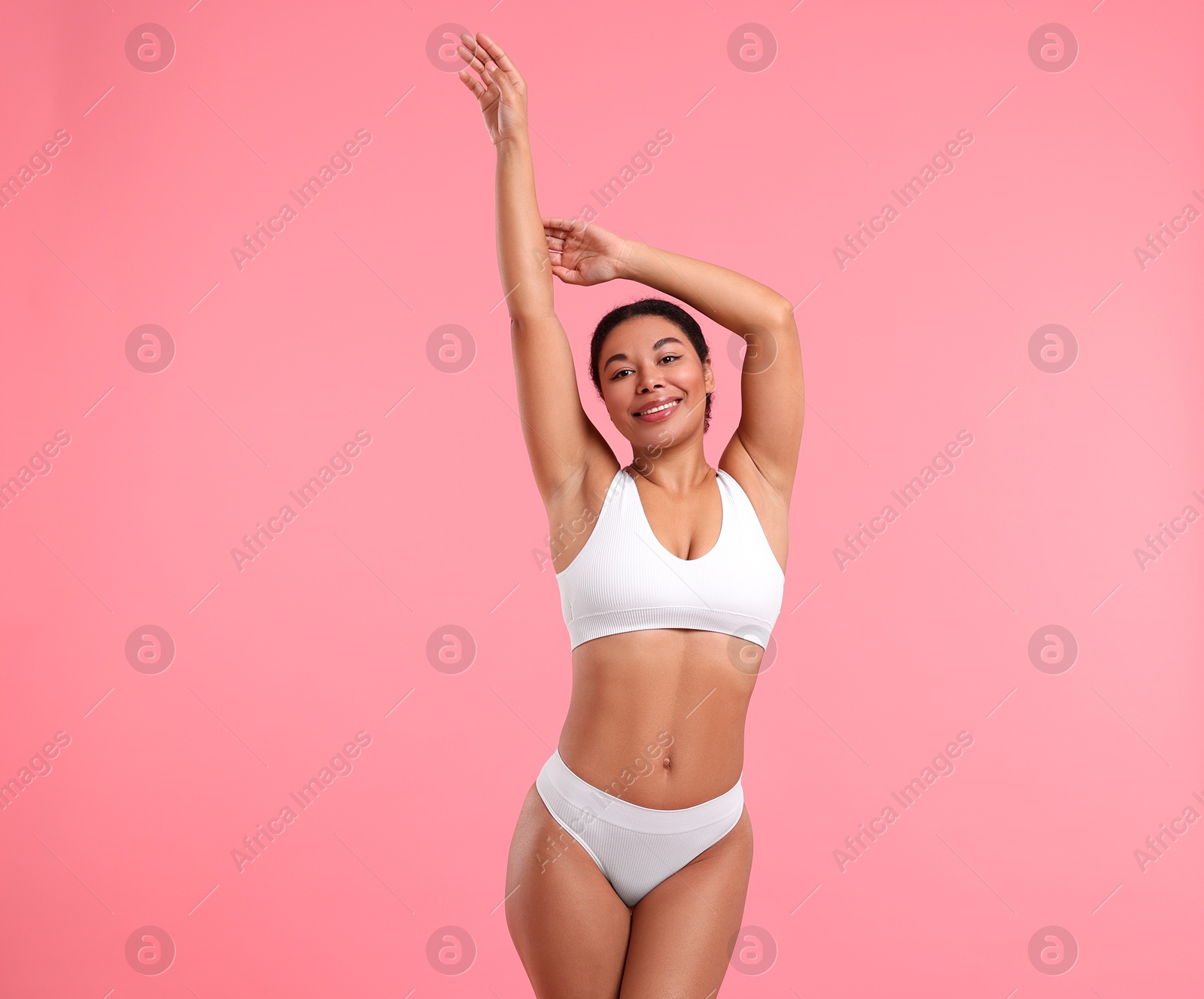 Woman in white underwear with smooth skin after epilation procedure on pink background Photo of Woman in white underwear with smooth skin after epilation procedure on pink background