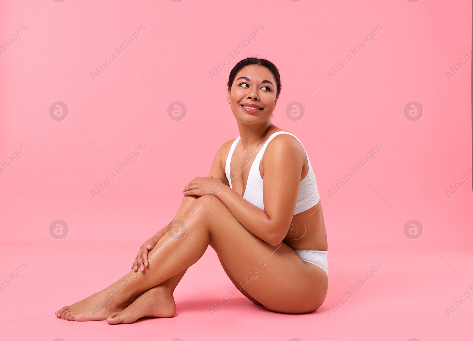 Photo of Woman in white underwear with smooth skin after epilation procedure on pink background