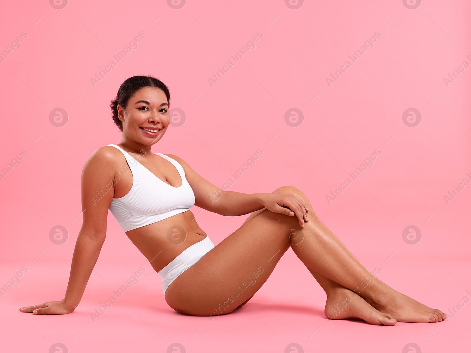 Photo of Woman in white underwear with smooth skin after epilation procedure on pink background