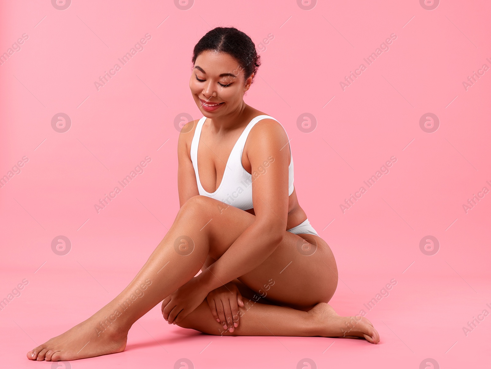 Woman in white underwear with smooth skin after epilation procedure on pink background Photo of Woman in white underwear with smooth skin after epilation procedure on pink background