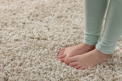 Photo of Girl on soft carpet at home, closeup. Space for text