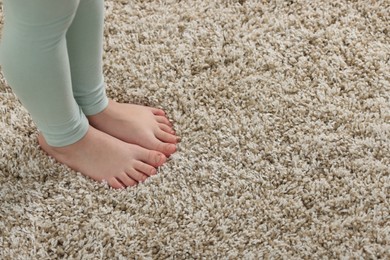 Photo of Girl on soft carpet at home, above view. Space for text