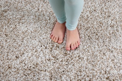 Photo of Girl on soft carpet at home, above view