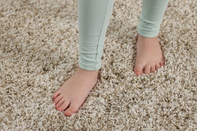 Photo of Girl on soft carpet at home, above view
