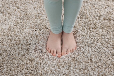 Photo of Girl on soft carpet at home, above view