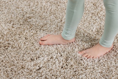 Photo of Girl on soft carpet at home, closeup. Space for text