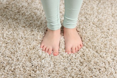 Photo of Girl on soft carpet at home, above view