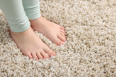 Photo of Girl on soft carpet at home, closeup. Space for text