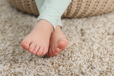Photo of Girl on soft carpet at home, closeup