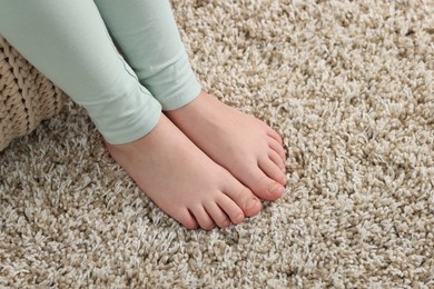 Photo of Girl on soft carpet at home, above view