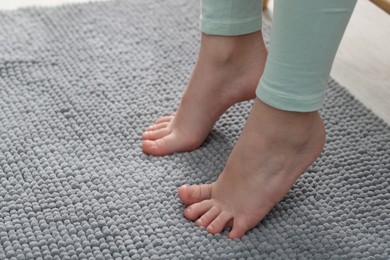 Photo of Girl on soft carpet at home, closeup. Space for text