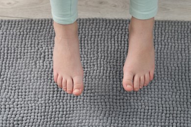 Photo of Girl above soft carpet at home, closeup