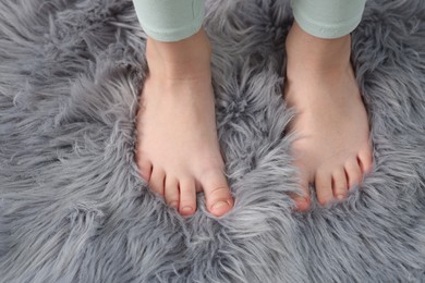 Photo of Girl on soft carpet at home, above view