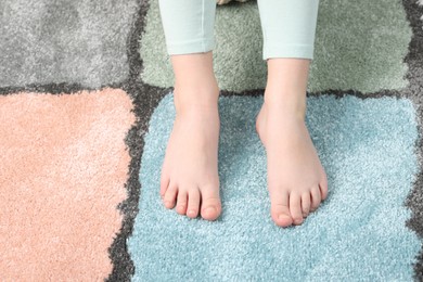 Photo of Girl on soft carpet at home, above view