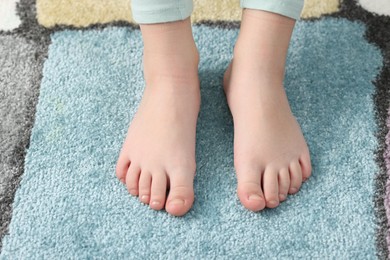 Photo of Girl on soft carpet at home, above view