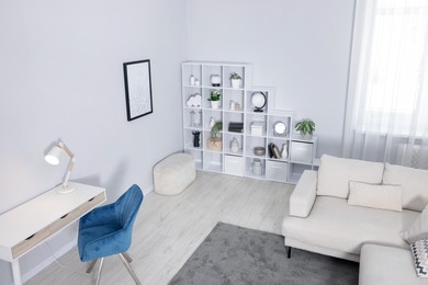 Photo of Comfortable sofa, shelving unit, table and armchair in living room, above view