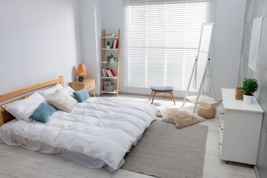 Photo of Comfortable bed, dresser and mirror in bedroom