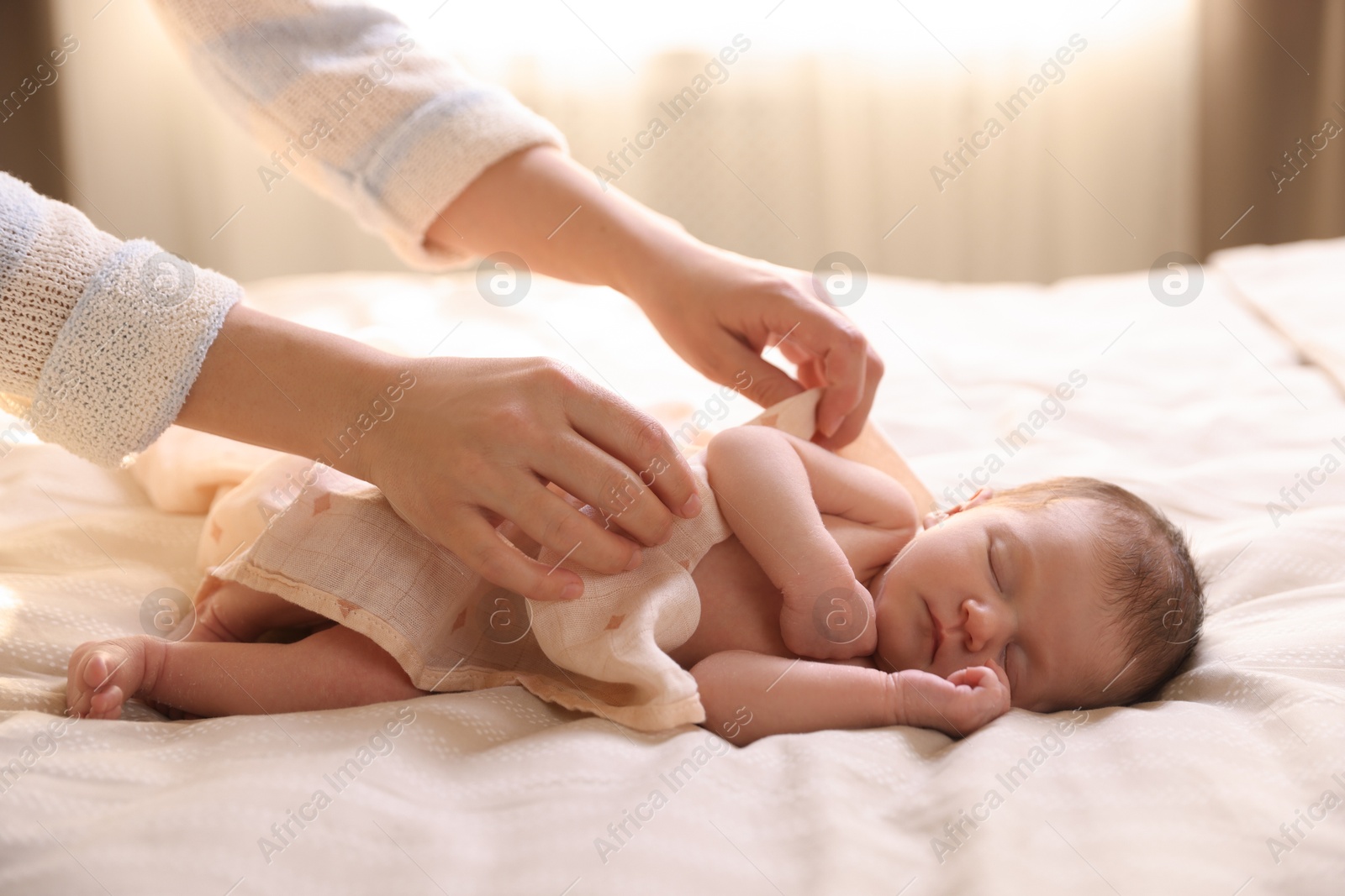 Bedtime. Mother covering her sleeping baby with blanket indoors, closeup Photo of Bedtime. Mother covering her sleeping baby with blanket indoors, closeup
