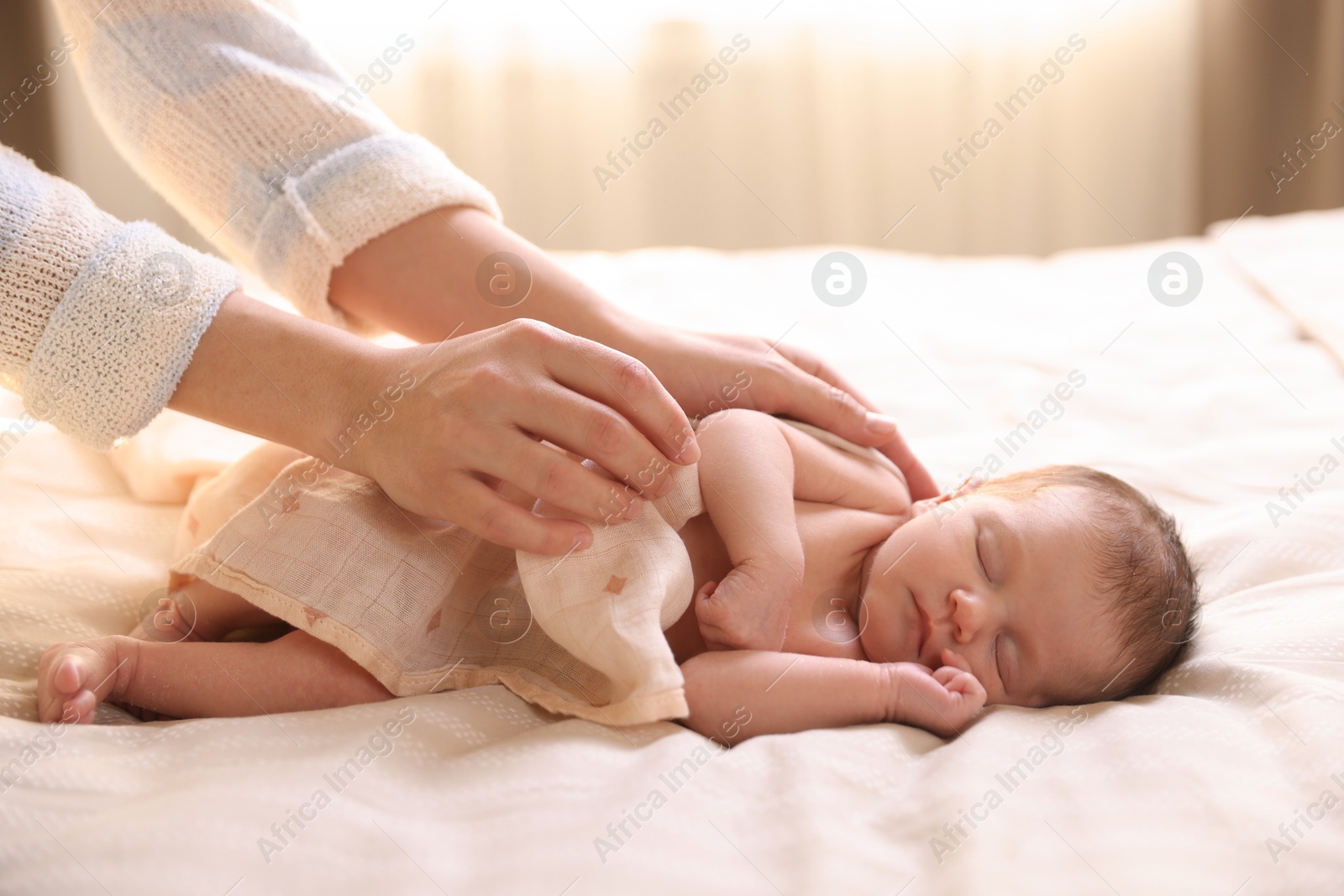 Bedtime. Mother covering her sleeping baby with blanket indoors, closeup Photo of Bedtime. Mother covering her sleeping baby with blanket indoors, closeup