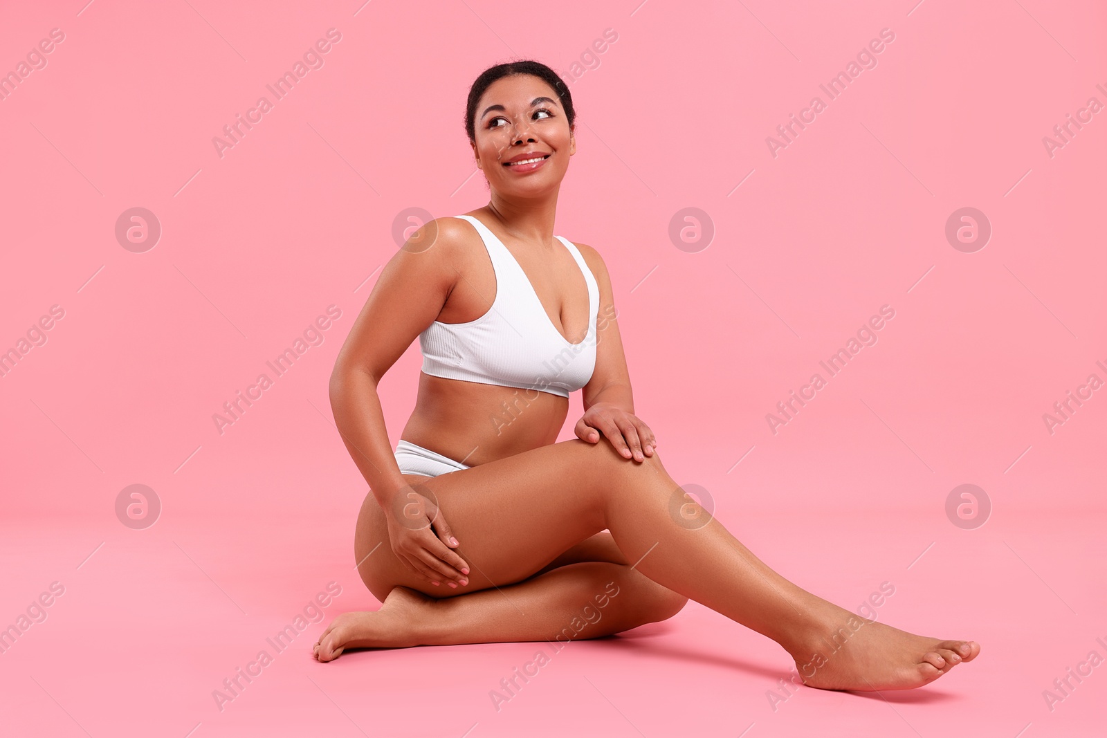 Photo of Woman in white underwear with smooth skin after epilation procedure on pink background