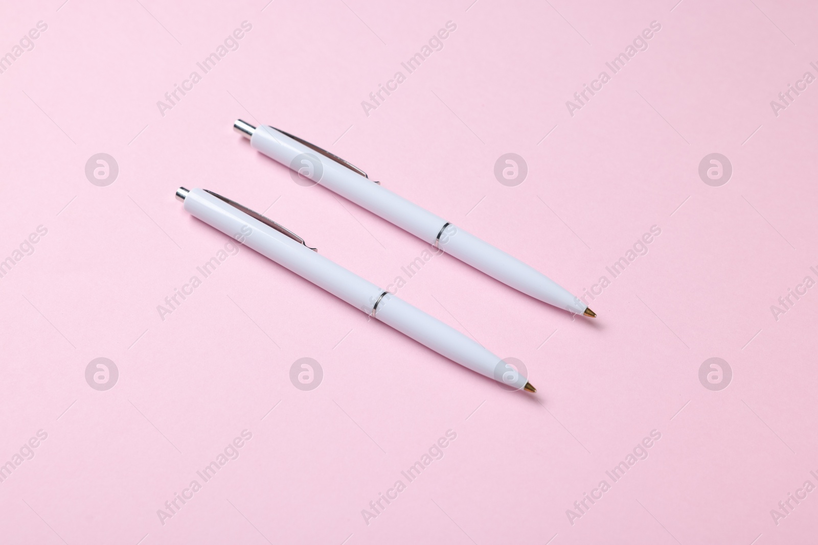 Ballpoint pens on pink background, above view Photo of Ballpoint pens on pink background, above view