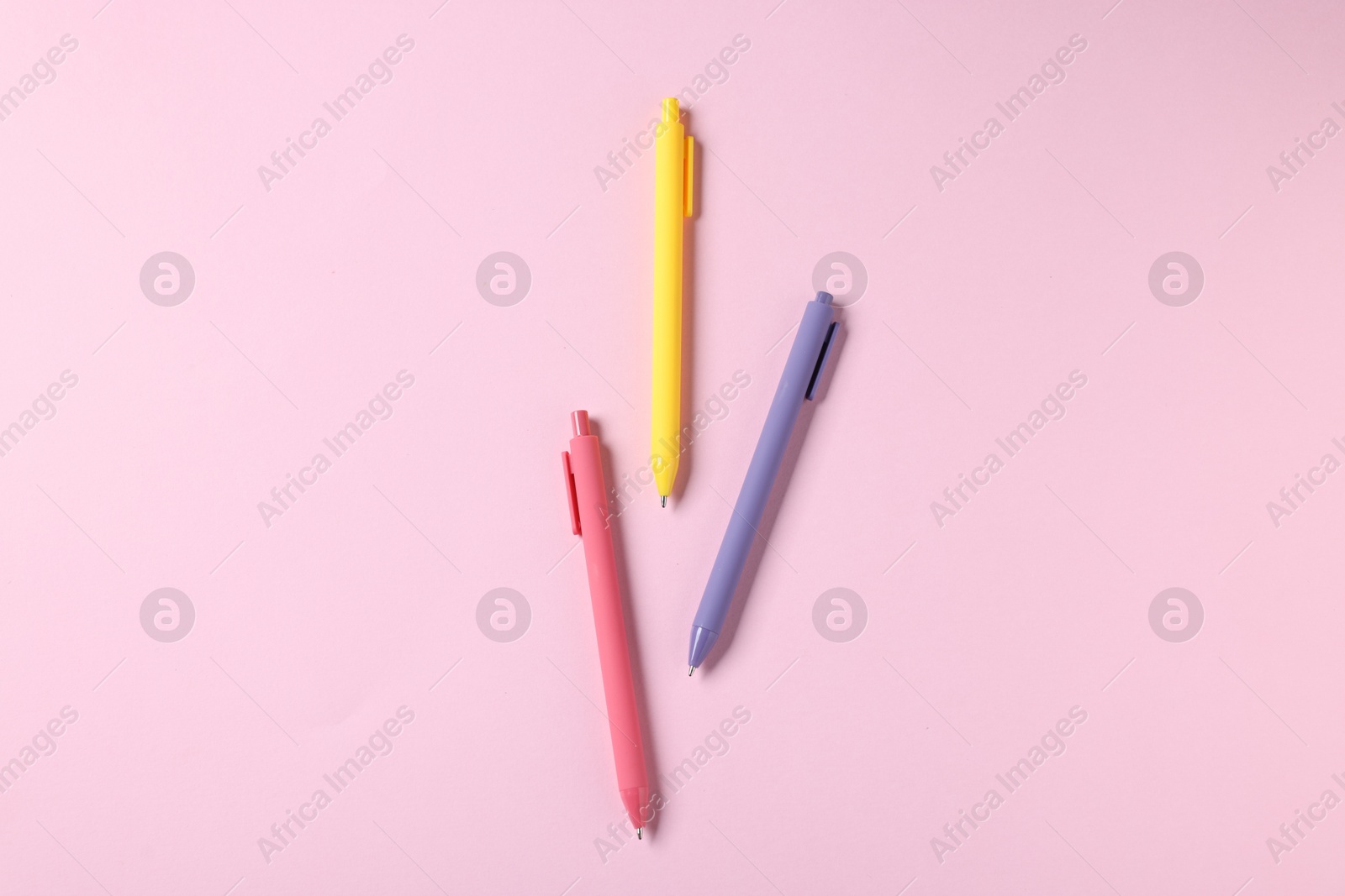 Set of ballpoint pens on pink background, flat lay Photo of Set of ballpoint pens on pink background, flat lay
