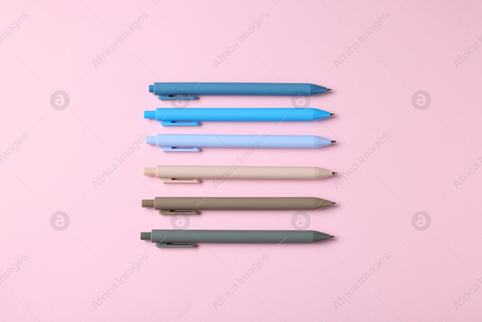 Set of ballpoint pens on pink background, flat lay Photo of Set of ballpoint pens on pink background, flat lay